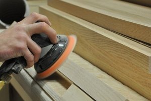 Photo of an employee sanding a stair.